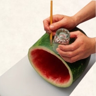 Draw a pencil line around the watermelon using a glass edge.