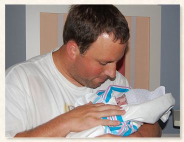 Travis Jones admiring his new little one, Luke